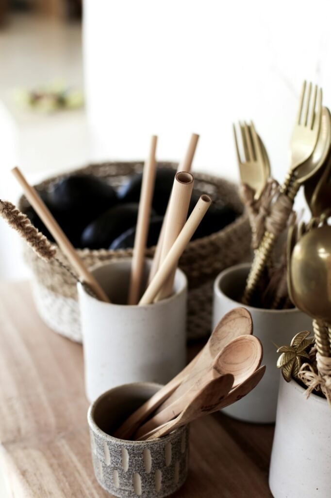 Natural bamboo and metallic eco cutlery standing on the wooden background.